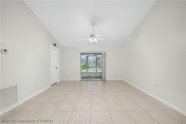 tiled empty room featuring ceiling fan and vaulted ceiling