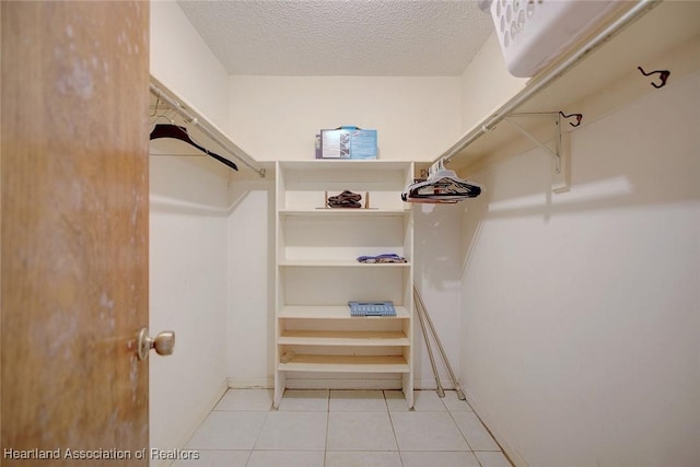 walk in closet with tile patterned flooring