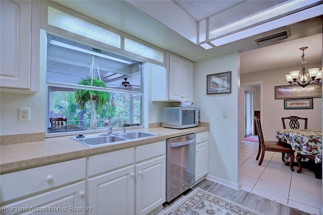 kitchen with stainless steel appliances, a sink, visible vents, white cabinetry, and light countertops