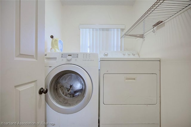 clothes washing area featuring washing machine and dryer and laundry area