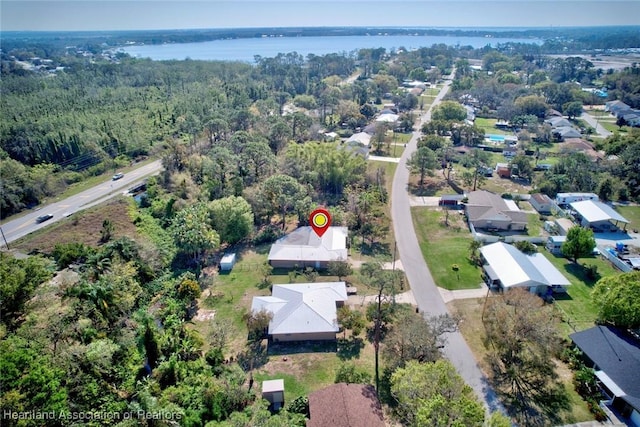 drone / aerial view with a water view and a forest view