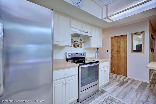 kitchen with under cabinet range hood, stainless steel appliances, white cabinetry, light wood-style floors, and light countertops