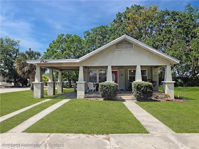 21 N French Ave, Fort Meade, FL 33841 - view of front facade featuring a porch, a front yard, a carport, and stucco siding
