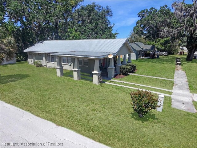 21 N French Ave, Fort Meade, FL 33841 - view of front of home with a front lawn and metal roof