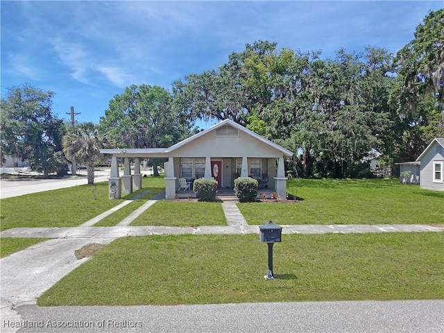 21 N French Ave, Fort Meade, FL 33841 - bungalow-style home with concrete driveway, covered porch, a front lawn, a carport, and stucco siding