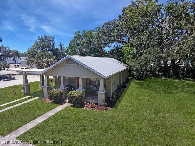 21 N French Ave, Fort Meade, FL 33841 - bungalow-style house with a porch, a front yard, and stucco siding