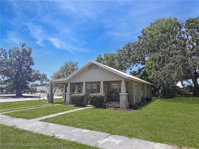 21 N French Ave, Fort Meade, FL 33841 - bungalow featuring a porch, a front lawn, and stucco siding