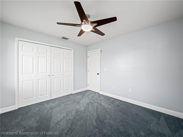 unfurnished bedroom with dark colored carpet, ceiling fan, and a closet