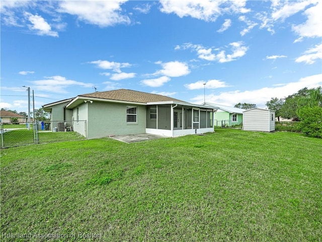 rear view of property featuring a patio area, a sunroom, and a yard