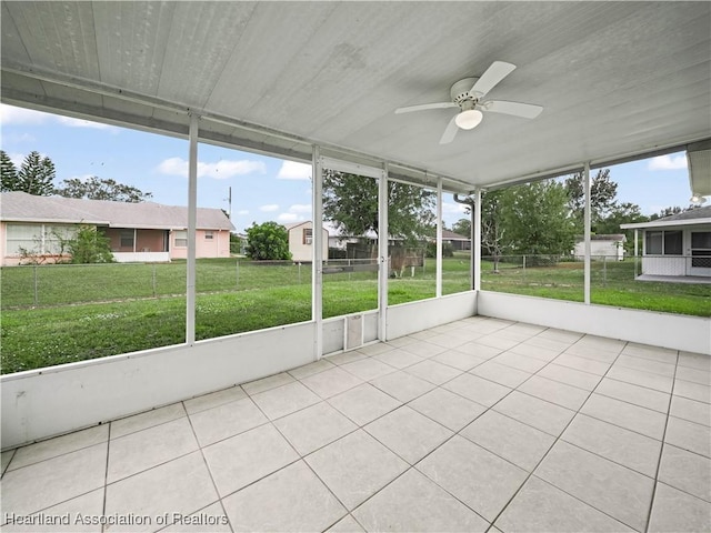 unfurnished sunroom featuring a wealth of natural light and ceiling fan