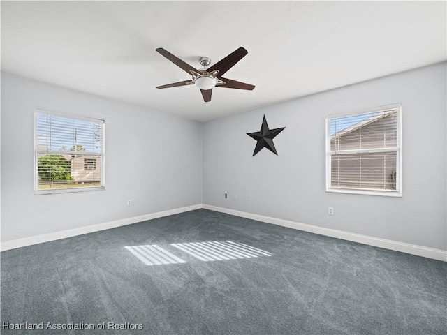 spare room with ceiling fan and dark carpet