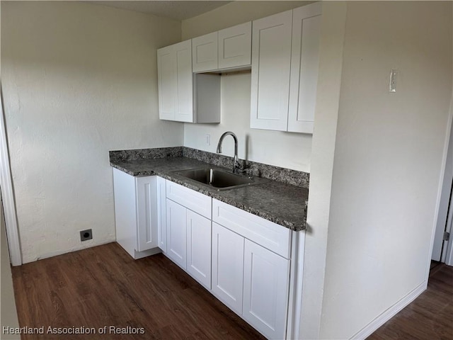 4504 High Ave, Sebring, FL 33870 - kitchen featuring a sink, dark wood-style flooring, dark countertops, and white cabinetry