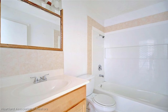 bathroom featuring toilet, vanity, and washtub / shower combination