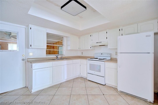 kitchen with white cabinets, white appliances, a raised ceiling, under cabinet range hood, and a sink