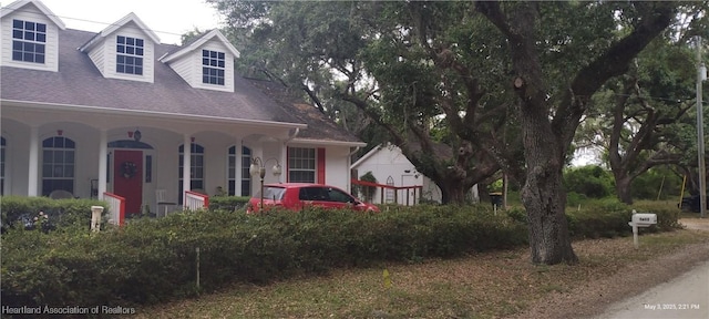 2212 Wolf Rd, Sebring, FL 33875 - cape cod home featuring covered porch, roof with shingles, and stucco siding