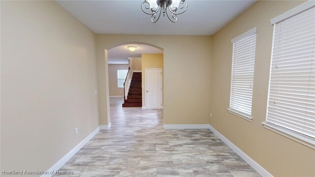 5406 Fishhawk Dr, Lithia, FL 33547 - hall featuring arched walkways, a notable chandelier, baseboards, and stairs