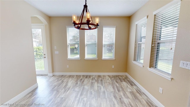 5406 Fishhawk Dr, Lithia, FL 33547 - unfurnished dining area featuring a notable chandelier, arched walkways, and baseboards