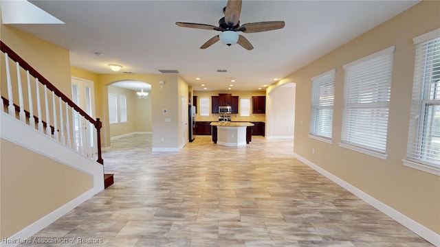 5406 Fishhawk Dr, Lithia, FL 33547 - unfurnished living room with arched walkways, recessed lighting, stairs, and baseboards
