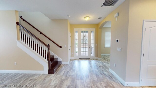 5406 Fishhawk Dr, Lithia, FL 33547 - entrance foyer featuring light wood-style floors, baseboards, visible vents, and arched walkways