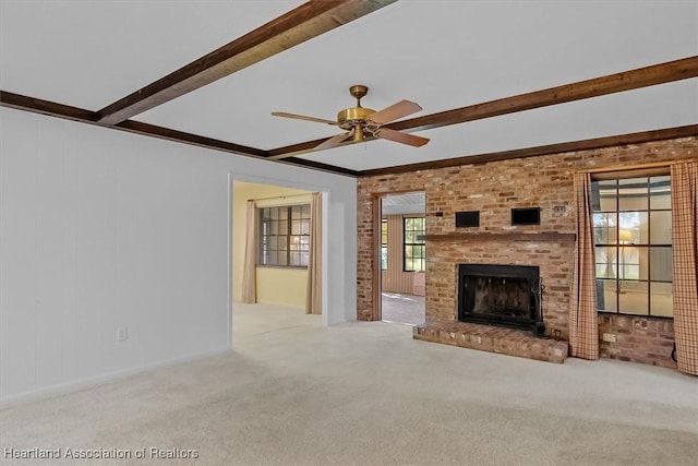 unfurnished living room with light colored carpet, a brick fireplace, ceiling fan, and ornamental molding