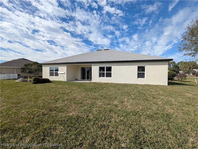 rear view of property with a lawn