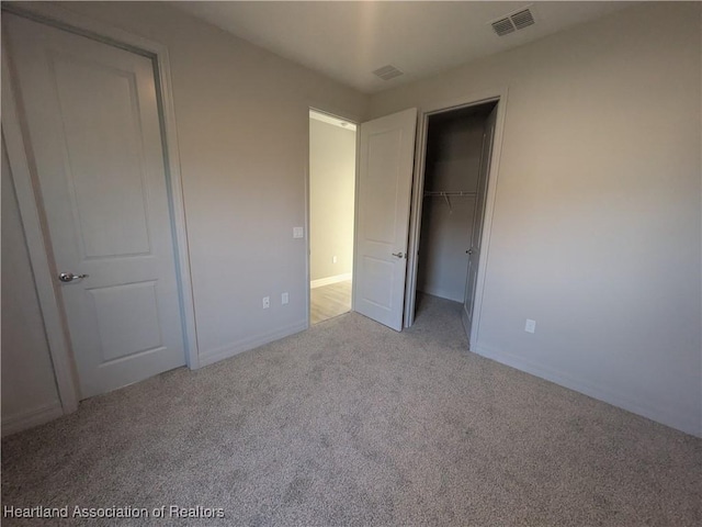 unfurnished bedroom with a closet and light carpet