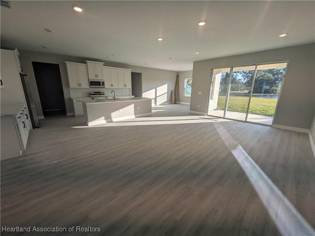 unfurnished living room with sink and light hardwood / wood-style flooring