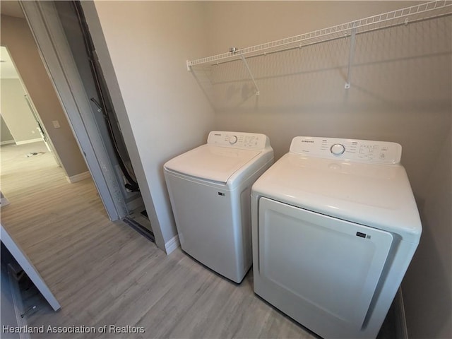 laundry area featuring light wood-type flooring and washing machine and clothes dryer