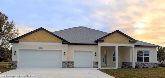 craftsman-style home featuring a garage and a lawn