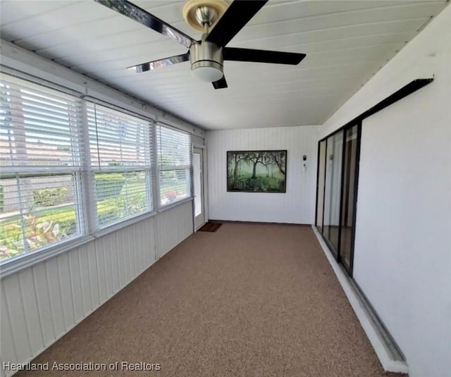 unfurnished sunroom featuring ceiling fan