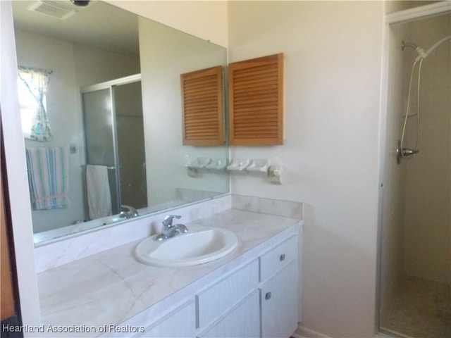 bathroom with an enclosed shower and vanity