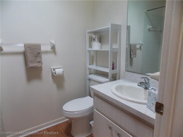 bathroom with vanity, wood-type flooring, and toilet