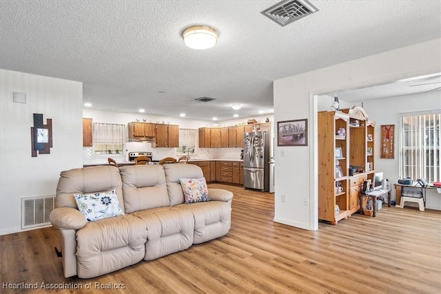 living room featuring a textured ceiling and light hardwood / wood-style flooring