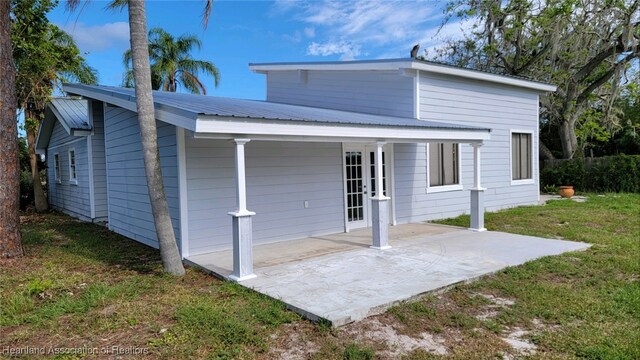 rear view of property featuring a patio area and a yard