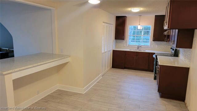 kitchen featuring range with electric cooktop, sink, hanging light fixtures, tasteful backsplash, and light hardwood / wood-style floors