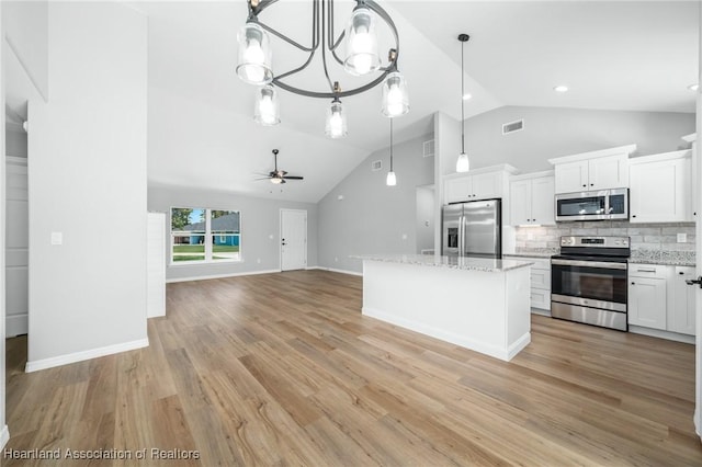 4225 Cooper Dr, Sebring, FL 33872 - kitchen with stainless steel appliances, ceiling fan, tasteful backsplash, white cabinetry, and a kitchen island
