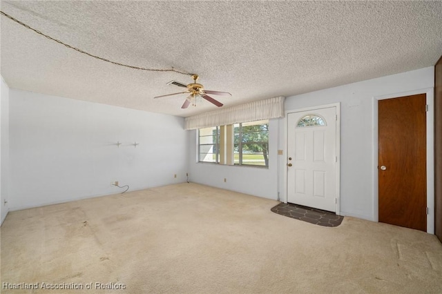 carpeted entryway with a ceiling fan and a textured ceiling