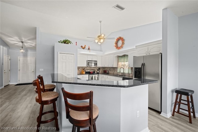 3730 Camry Ct, Sebring, FL 33872 - kitchen with appliances with stainless steel finishes, light wood-type flooring, white cabinets, decorative backsplash, and ceiling fan