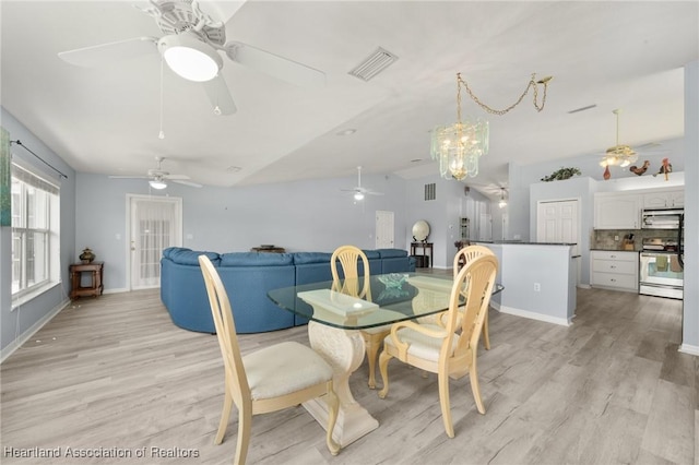 3730 Camry Ct, Sebring, FL 33872 - dining area with vaulted ceiling, ceiling fan, light wood finished floors, and a chandelier