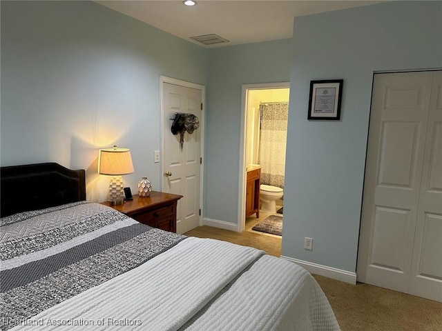 carpeted bedroom featuring ensuite bath and a closet