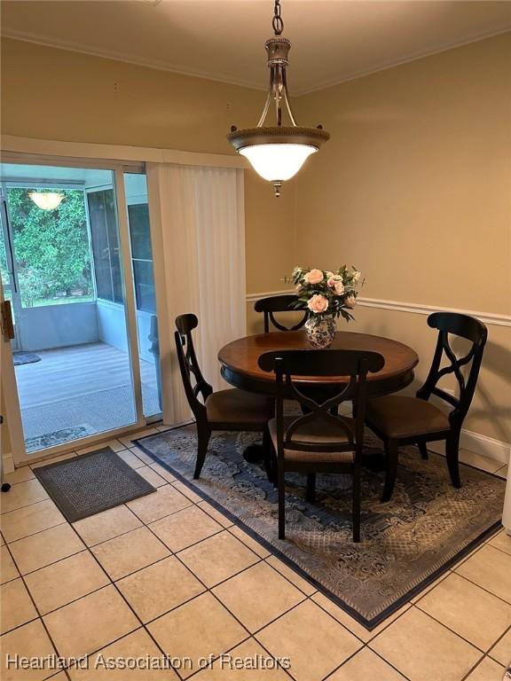 dining area with light tile patterned floors and crown molding