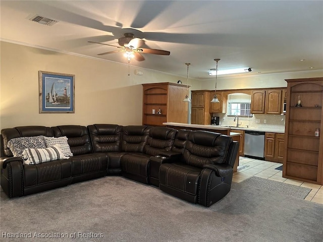 living room featuring light tile patterned floors, ceiling fan, ornamental molding, and sink