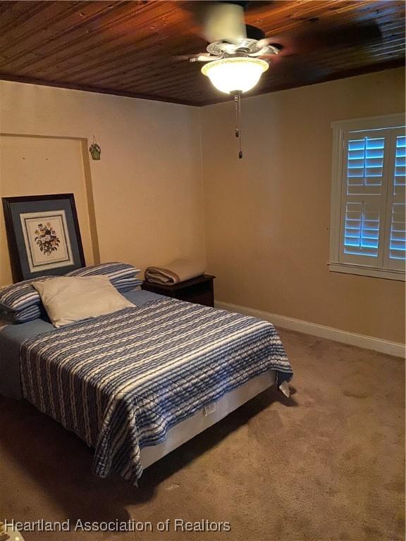 carpeted bedroom with wooden ceiling, ceiling fan, and baseboards