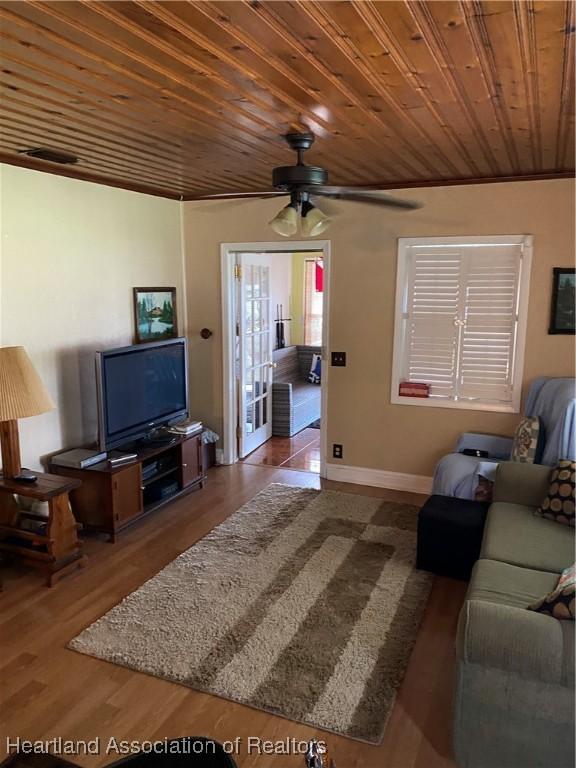 living room featuring ceiling fan, wooden ceiling, wood finished floors, and baseboards