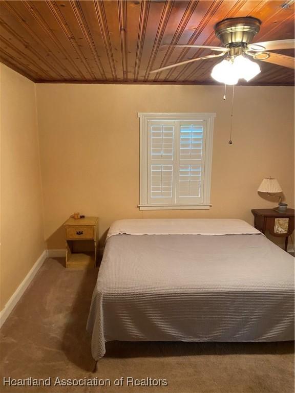 bedroom featuring ceiling fan, carpet floors, wooden ceiling, and baseboards