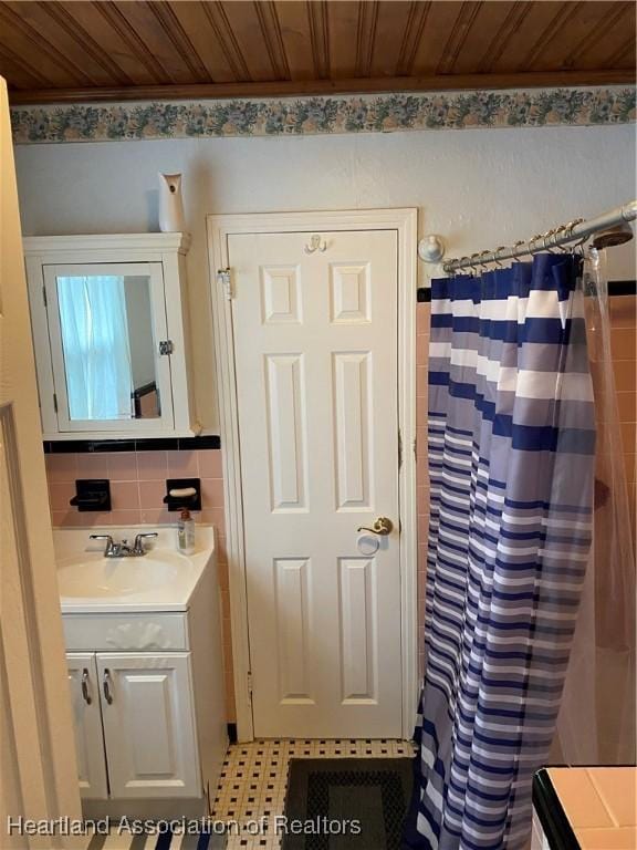 full bathroom with a shower with shower curtain, vanity, wood ceiling, tile walls, and tasteful backsplash