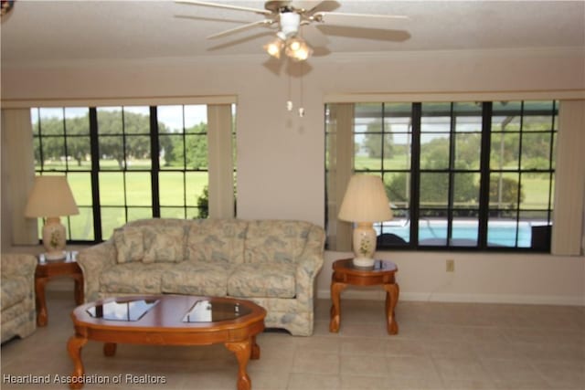 living room featuring ceiling fan, a healthy amount of sunlight, and crown molding