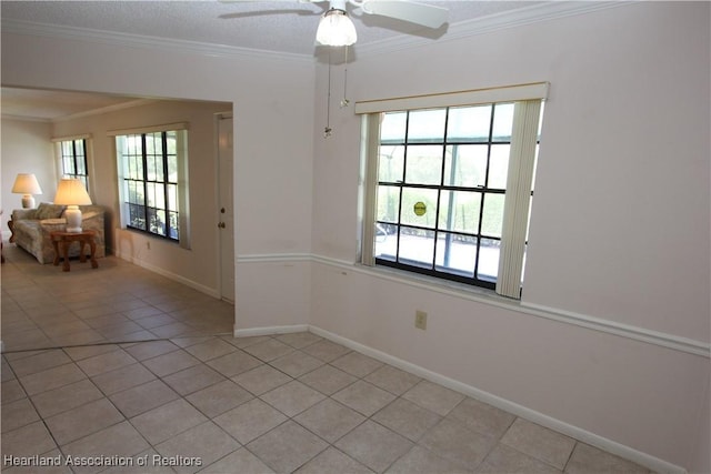 empty room featuring ceiling fan, light tile patterned flooring, a textured ceiling, and ornamental molding