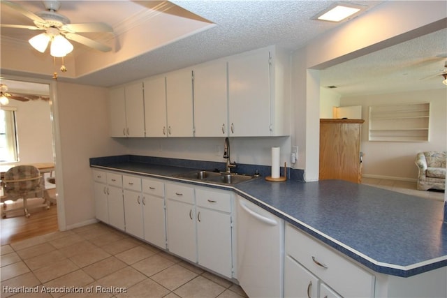 kitchen featuring dishwasher, sink, white cabinets, and light tile patterned floors