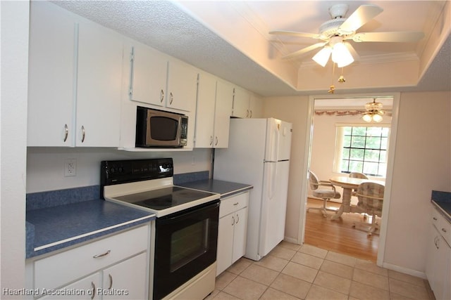 kitchen with white appliances, white cabinets, a raised ceiling, ceiling fan, and light tile patterned floors